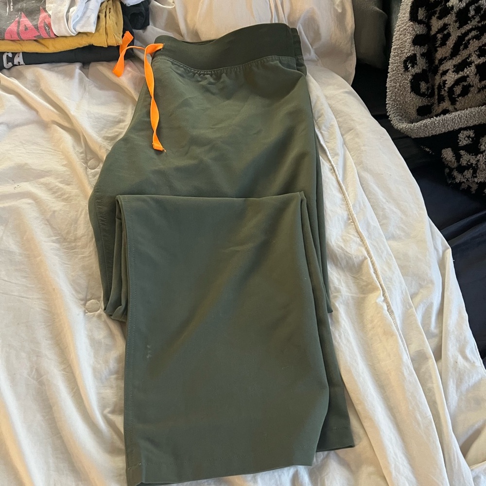 Figs technical collection size large , green with orange tie at waist .